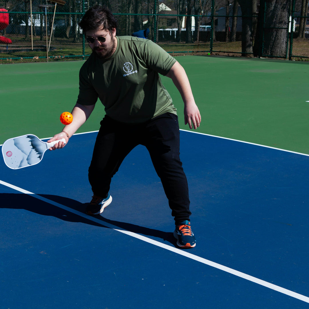 An informational image showing various materials used in the construction of pickleball paddles. Display multiple types of paddles side by side, such as those made from graphite, composite, and wood. 