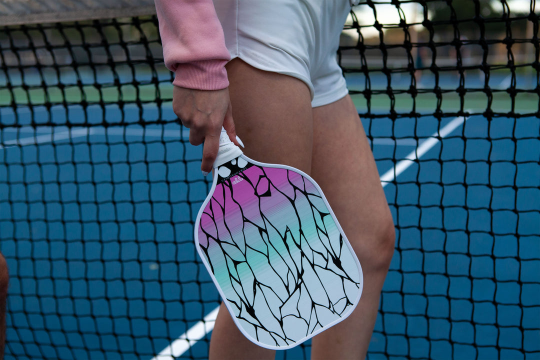 Girl holding a shinobu pickleball paddle from Tokyopaddles on a pickleball court.