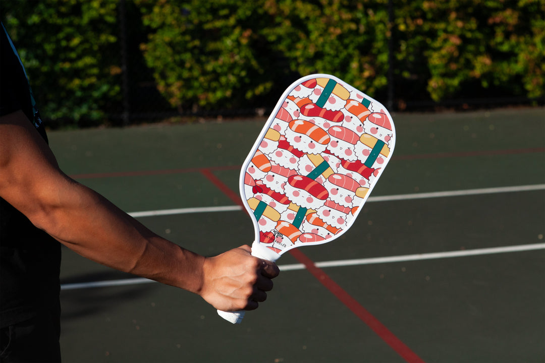 Man displaying a Sushi Squad pickleball paddle from TokyoPaddles.